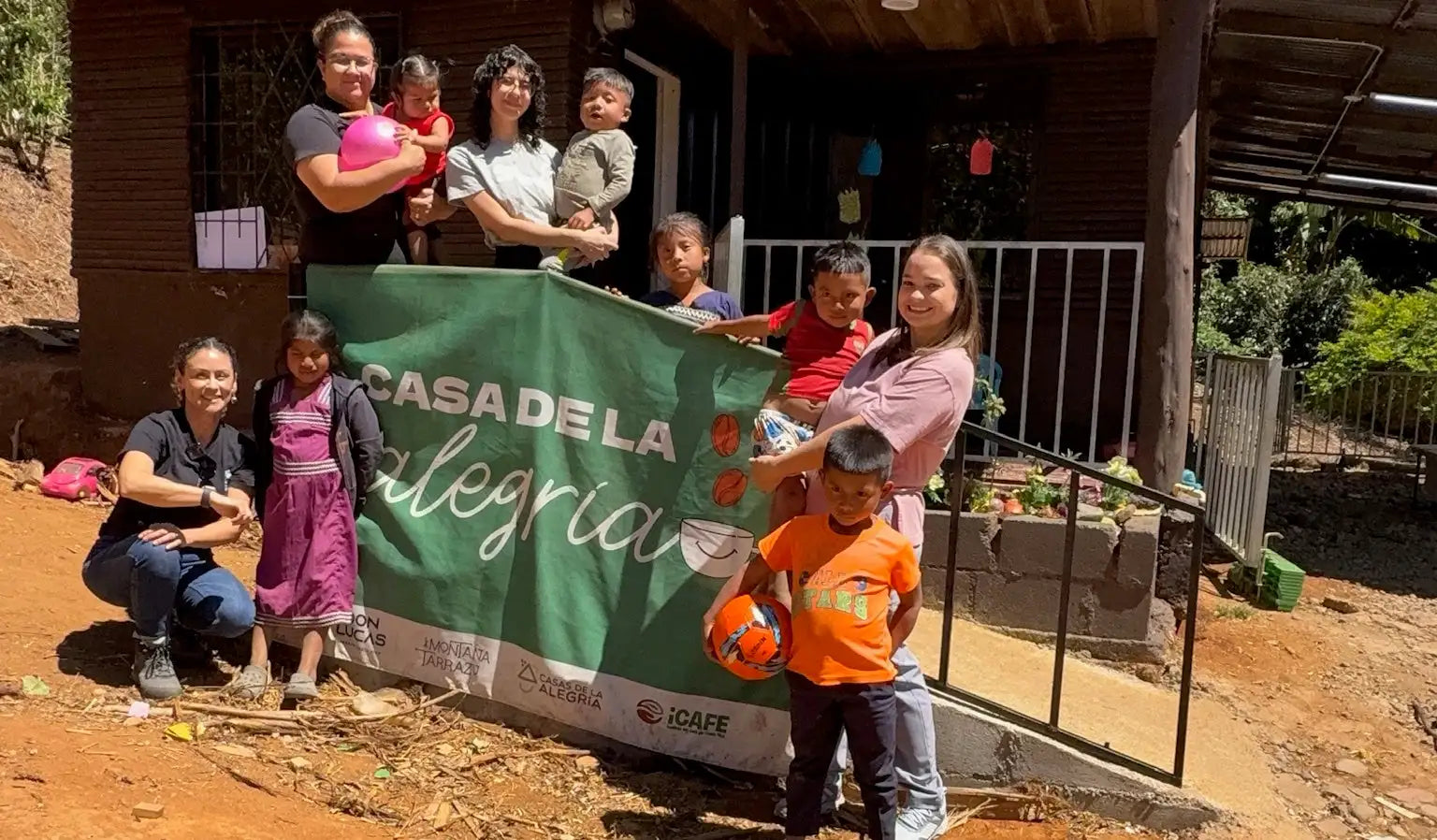 Green banner with white text reading ’casa de la alegría’ and a smiling face logo, featuring logos of supporting organizations at the bottom.